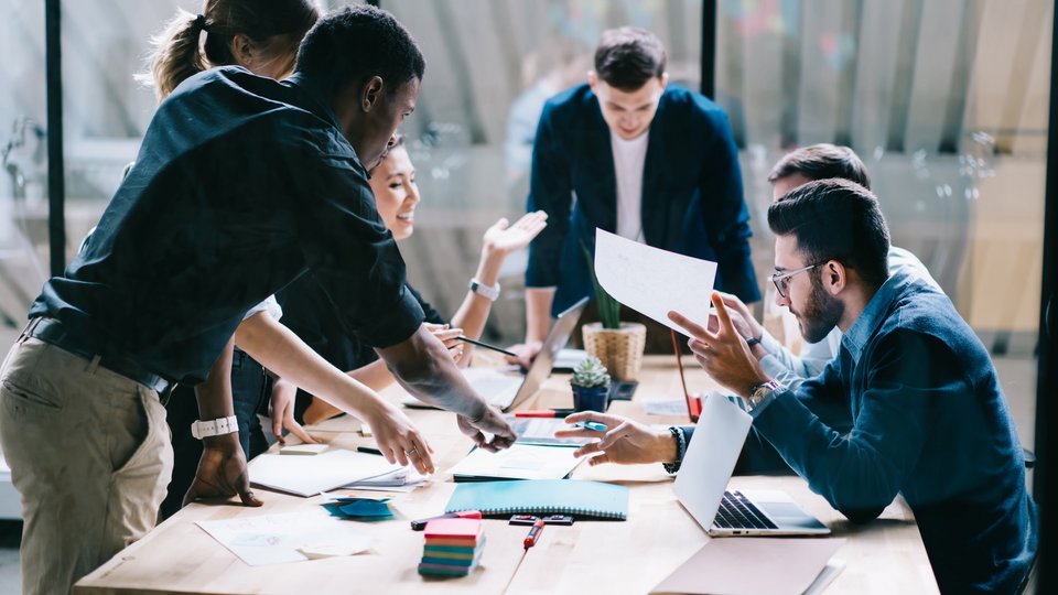 Arbeitende Angestellte, die an einem Tisch diskutieren 